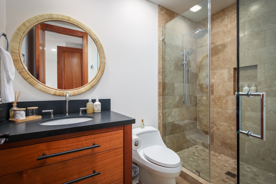 Guest Suite #2’s en suite bath with glass enclosed shower.