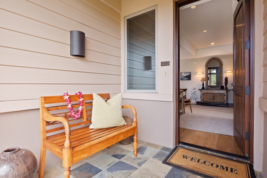 Step into your welcoming retreat where a charming teak bench greets you at the entrance, adorned with tropical touches and soft cushions for relaxing moments.