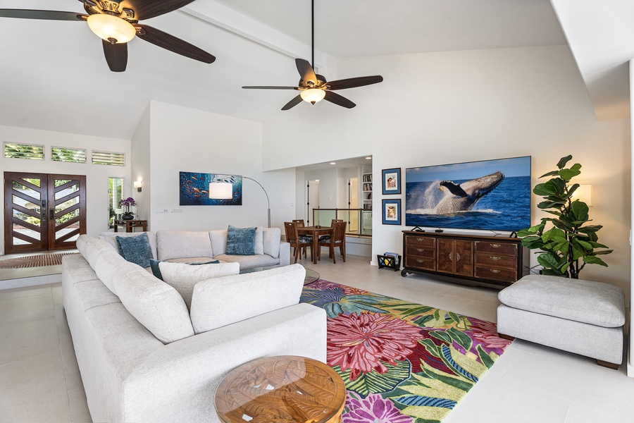 Cozy secondary lounge perfect for reading, streaming, or game time, accented by colorful island textiles and greenery.