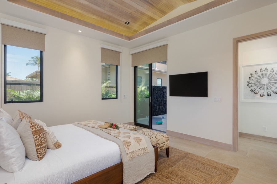 This refined bedroom offers a serene escape, highlighted by its sleek design and direct access to a private lanai.