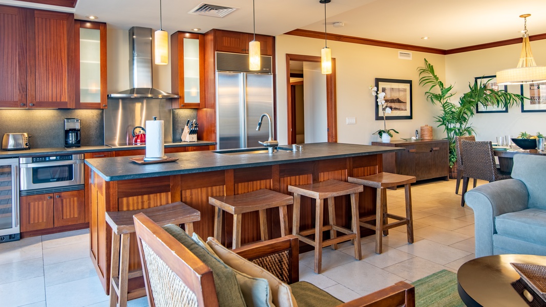 A well equipped kitchen with stainless steel appliances and bar seating.