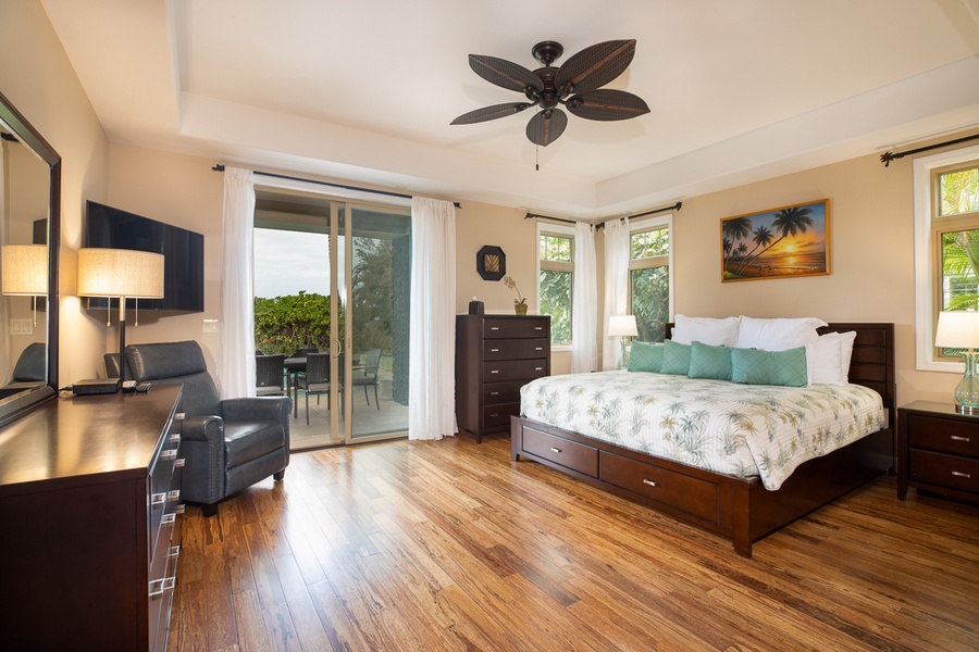 The home's spacious primary suite features a king-size bed, direct access to the hot tub and pool