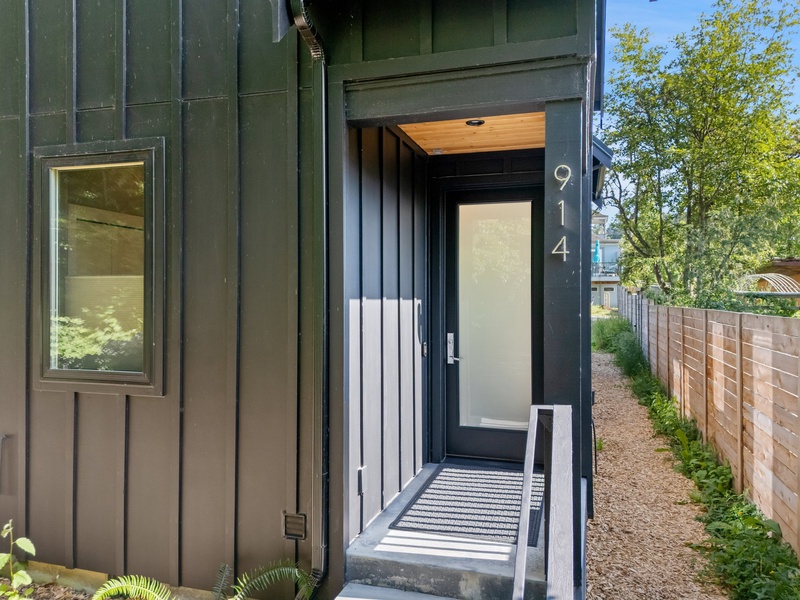 The entry sets a modern tone with clean lines and forested privacy.