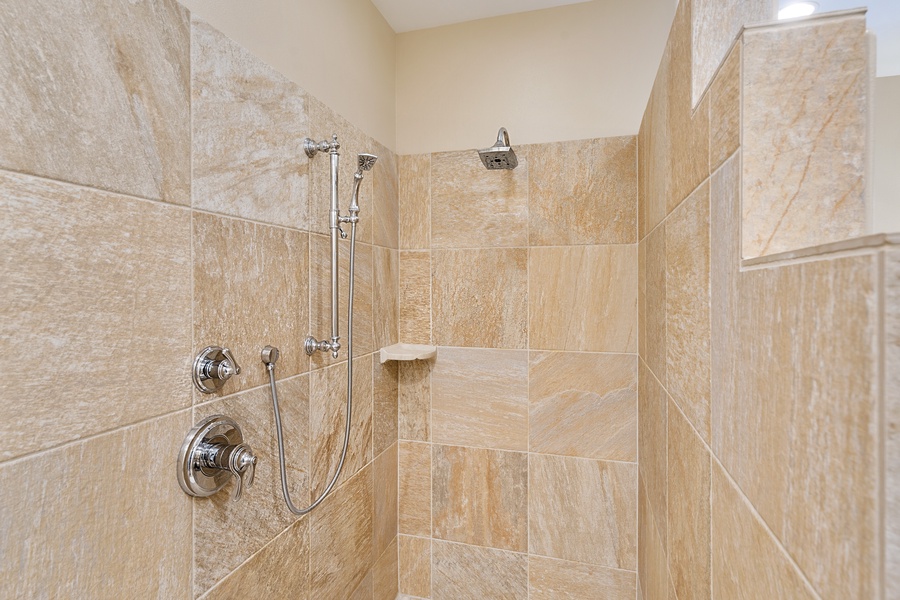 Refresh in the luxurious walk-in shower of Kona Blue Vacations Holua Kai’s primary suite bathroom.