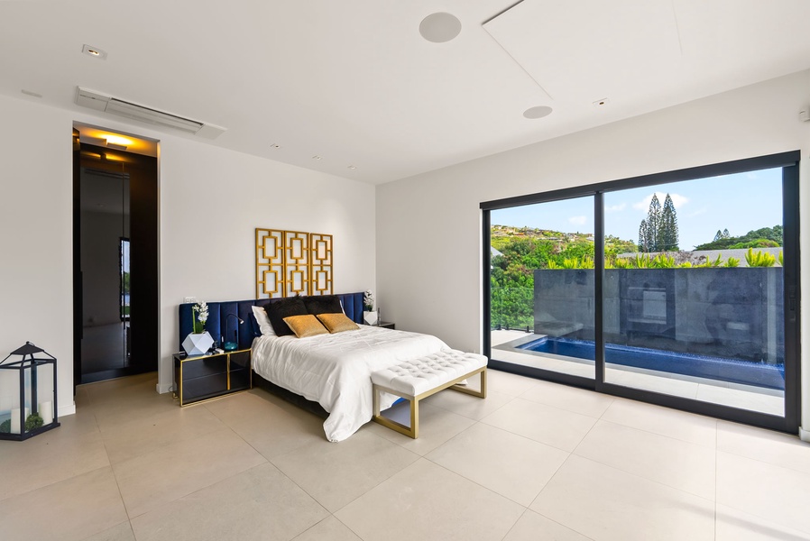 Airy queen bedroom with direct pool views and seamless indoor-outdoor flow.