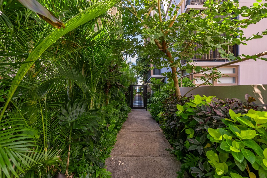 Lush garden pathway leading to your private retreat, surrounded by vibrant greenery for a tropical escape.