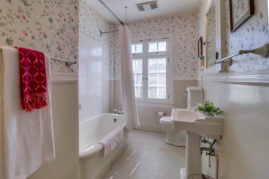 The jack and jill bathroom shared between guest rooms 3 and 4 features a spacious soaking tub perfect for unwinding, complemented by a stylish single vanity.