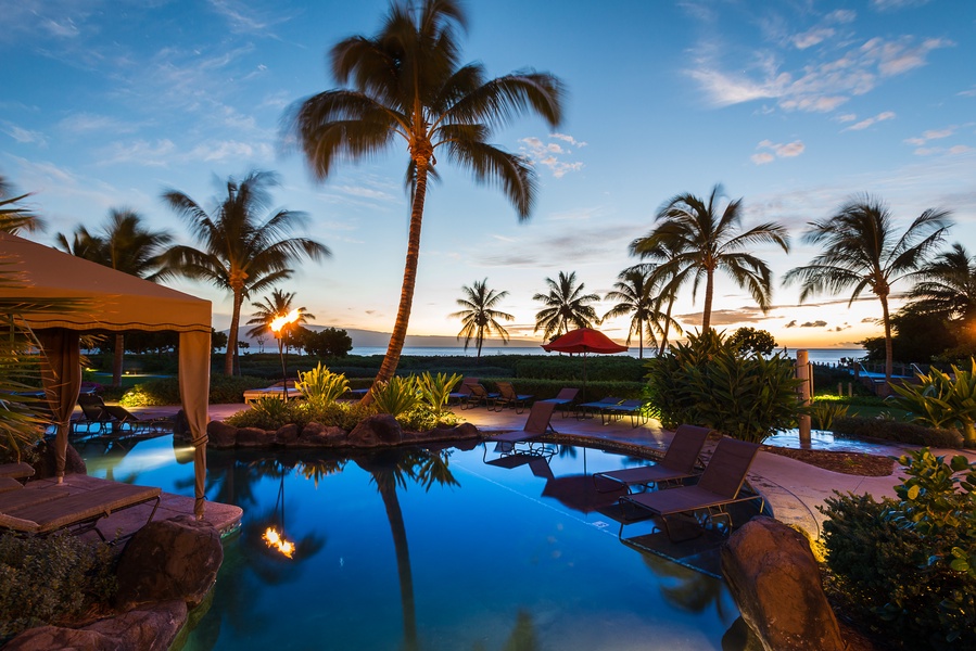 Evening poolside at Hokulani 214 with swaying palms and a peaceful Maui breeze.