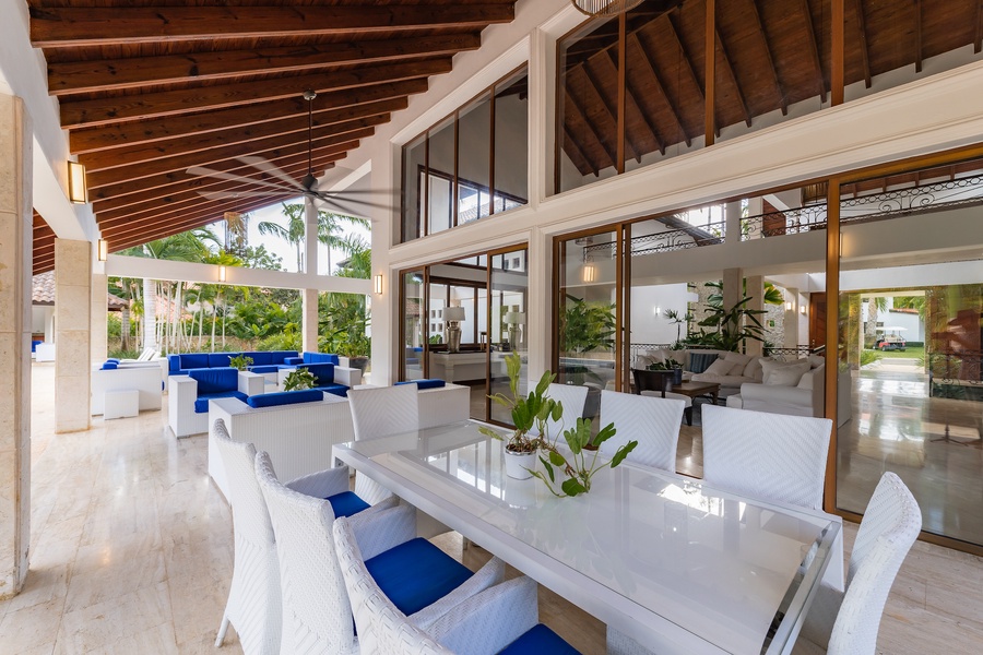 Dine al fresco in this charming outdoor dining area, complete with elegant white furniture and garden views.