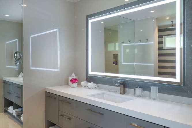 Guest ensuite with sleek finishes, LED-lit mirror, and spacious vanity.