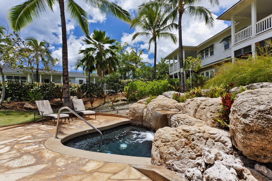 Unwind in the resort community hot tub surrounded by natural stone landscaping and swaying palms in this tropical paradise.
