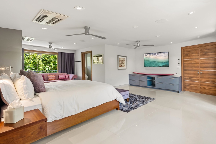 Sink into crisp white linens and wake to leafy garden views from your spacious bedroom, where modern comfort meets tropical serenity.