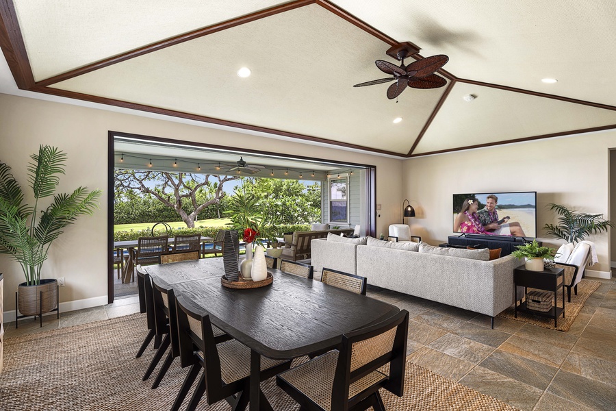 Breakfast lingers at this table, the great room open and the fan turning overhead.
