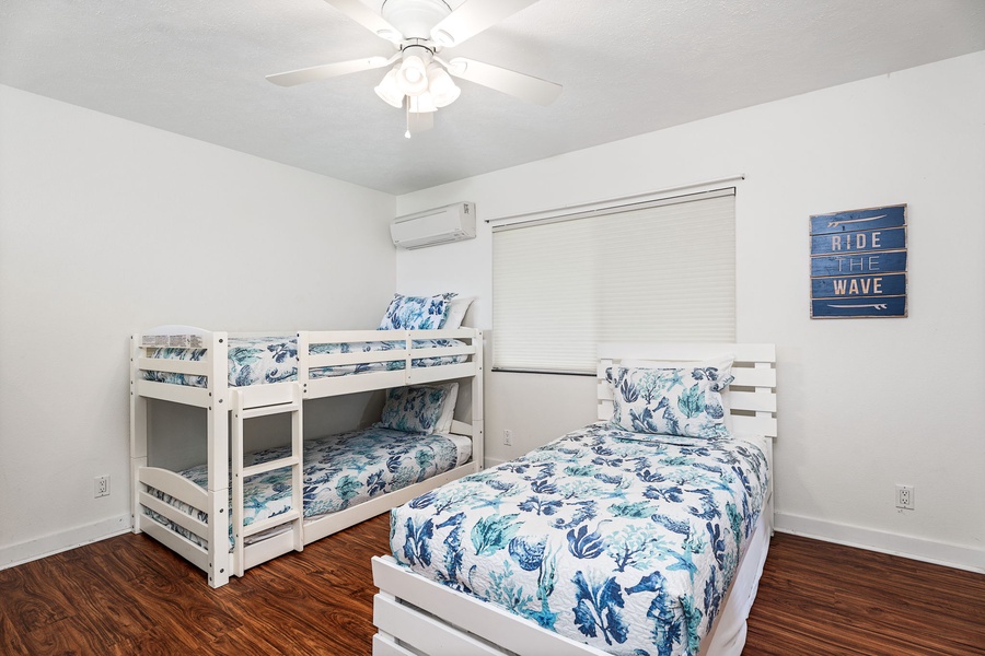 Your coastal-themed bedroom features a bunk bed and twin bed with ocean-inspired linens, perfect for family stays.