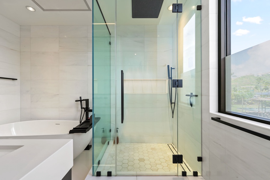 A sleek walk-in shower with a rainfall head and frameless glass enclosure offers a spa-like refresh after ocean adventures.