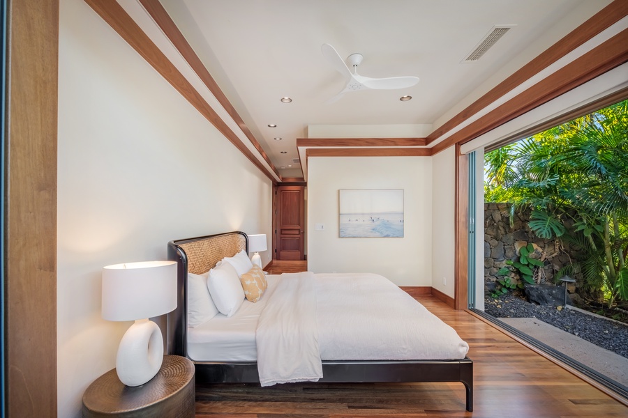 Guest Suite 2 with a king-size bed, surrounded by vibrant greenery and natural light.