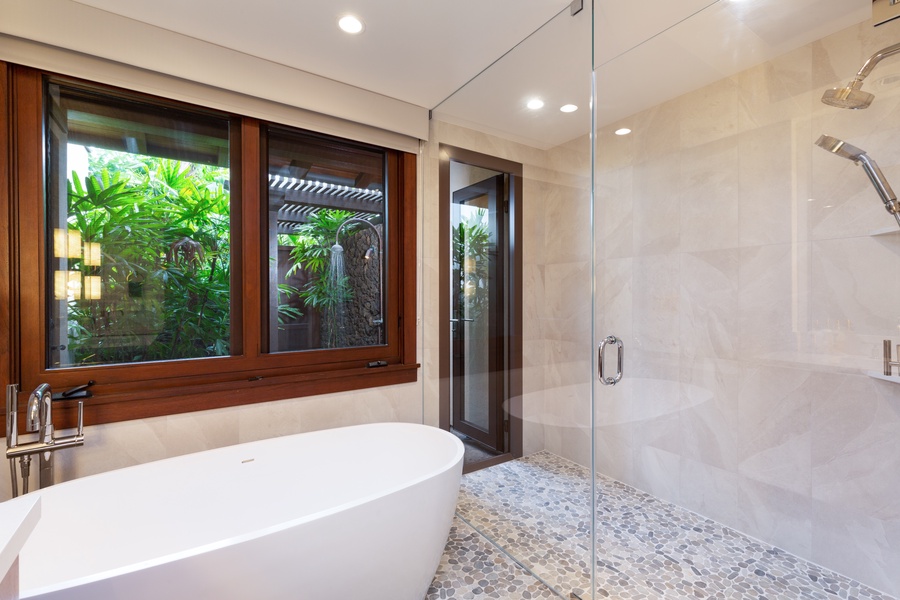 Oversized deep soaking tub with view to outdoor shower garden