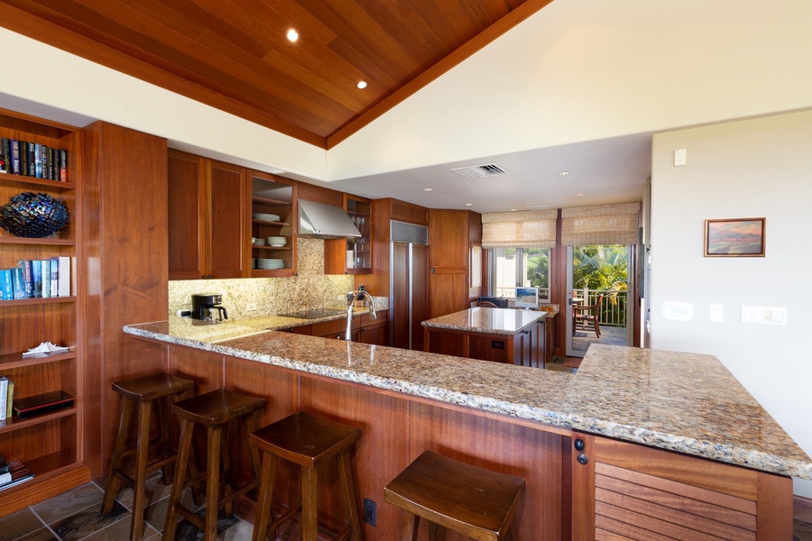 Four bar seats line the countertop, perfect for conversation with the chef during meal prep.