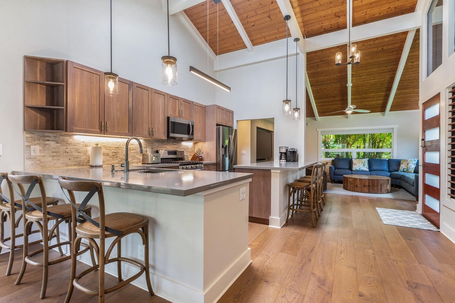 Lani Oasis’ chef-ready kitchen includes stainless steel appliances, a large island with bar seating, and open flow to dining and living spaces.
