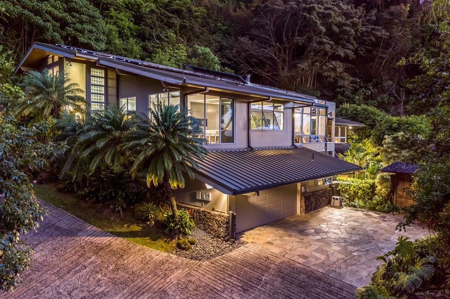Lower-level exterior showcasing the estate’s tiered design and lush, gated surroundings.