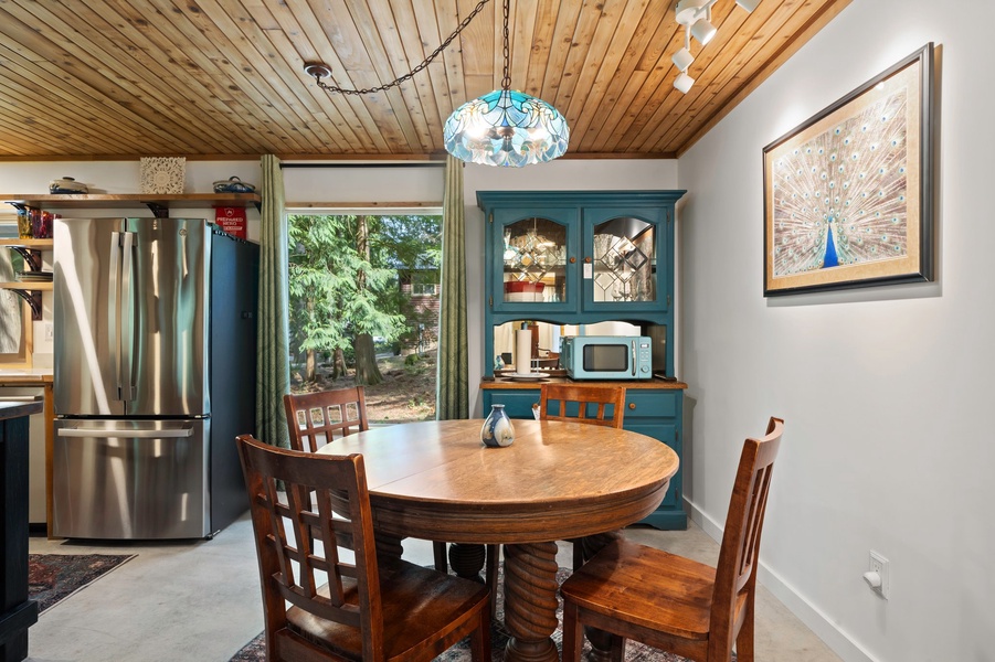 The dining nook is framed by forest views, offering the perfect backdrop for leisurely breakfasts or candlelit dinners.