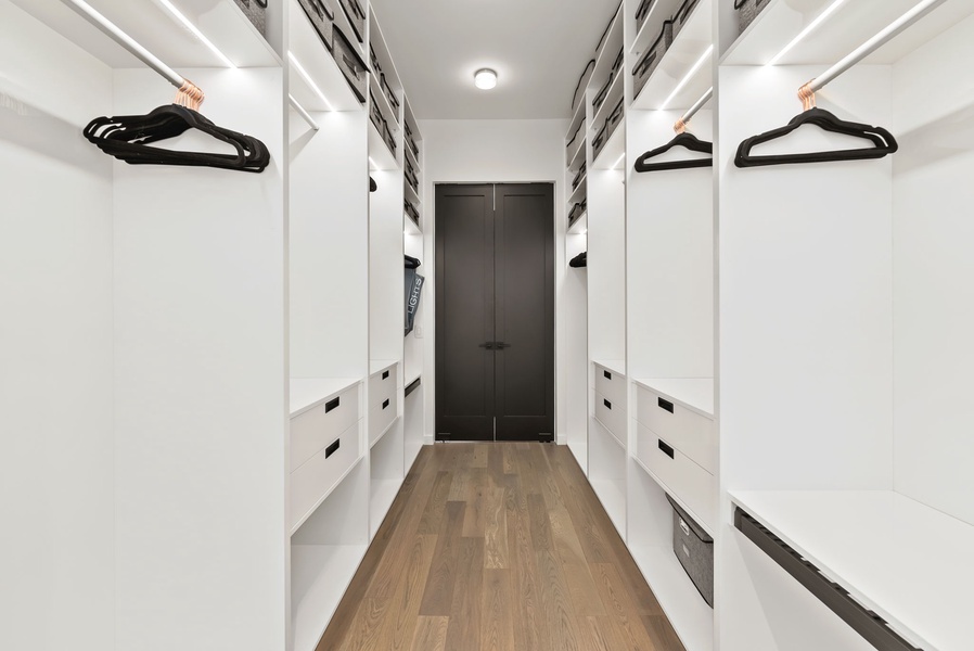 Spacious walk-in closet with custom shelving and streamlined storage.
