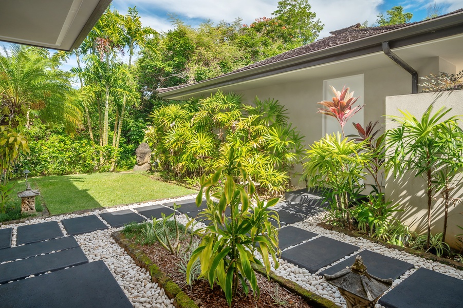 Tranquil garden pathway with lush tropical plants, perfect for a nature-filled stroll just outside your door.