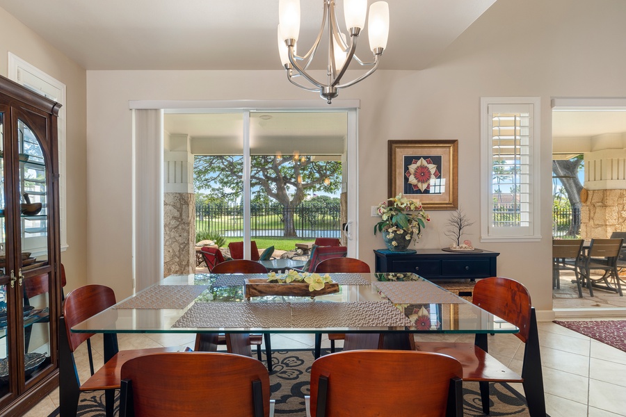 Gather around this elegant glass dining table where natural light streams through windows, creating the perfect space for memorable meals together.