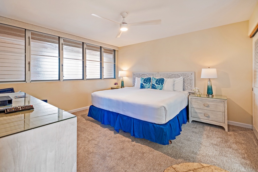 The guest bedroom at Royal Kahana 610 offers a spacious king-sized bed and plenty of natural light for a relaxing stay.
