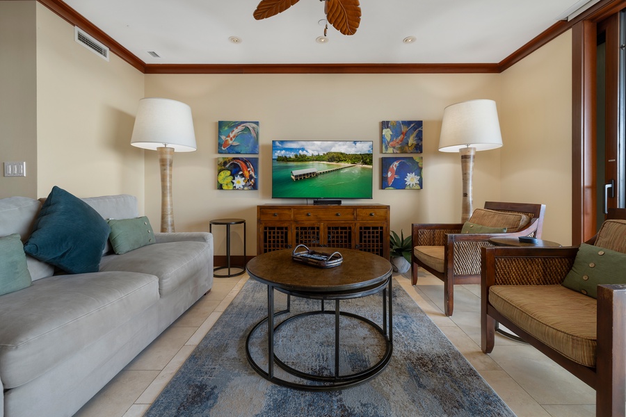 The living area features a large smart TV and comfortable sofas.