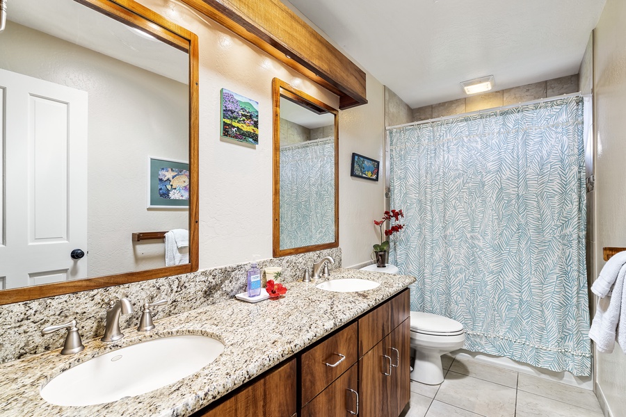 Guest bathroom equipped with dual vanities and shower/tub combo