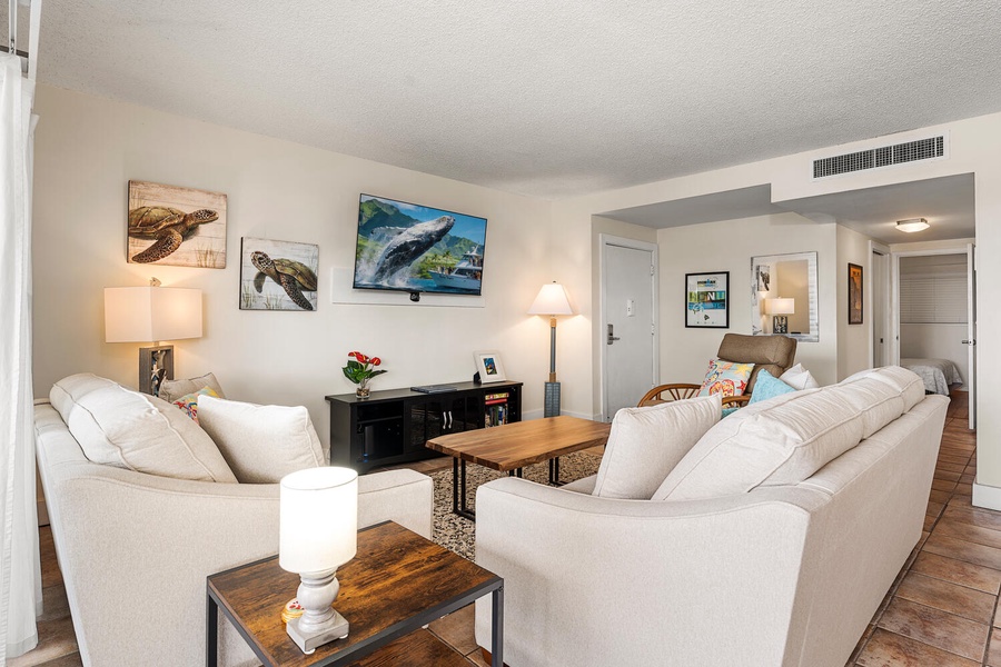 Sink into plush sofas while ocean-inspired art surrounds you in this bright, welcoming space perfect for relaxing together.