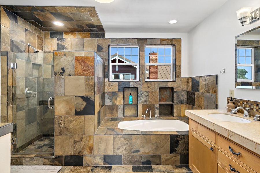 Indulge yourself and unwind as you soak in the inviting hot tub, a perfect spot for relaxation. A walk-in shower is also present for your convenience.