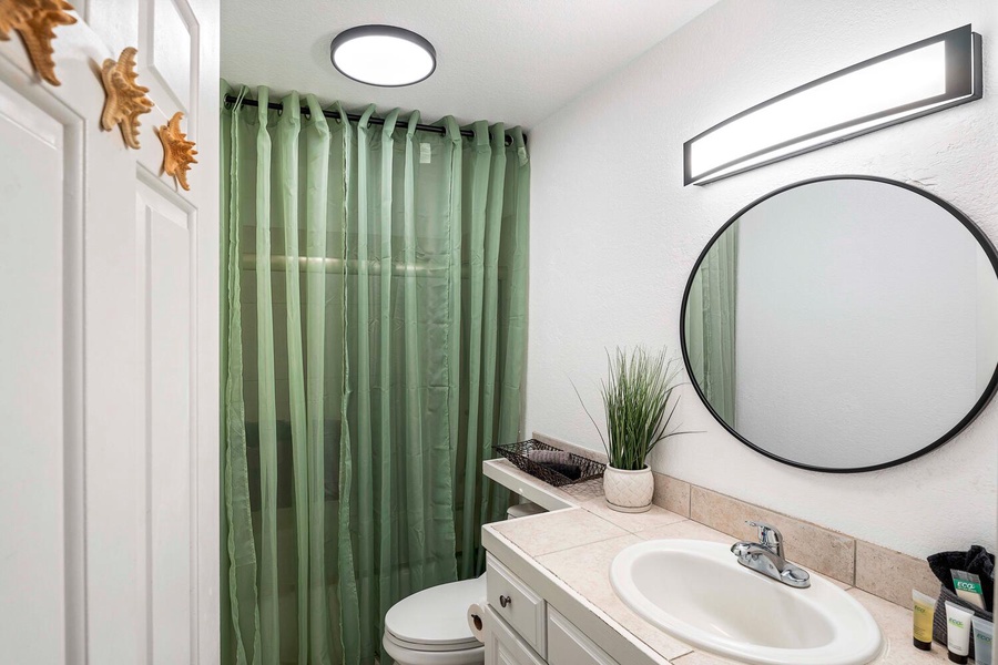 Full bathroom with shower/tub combo and ample vanity space.