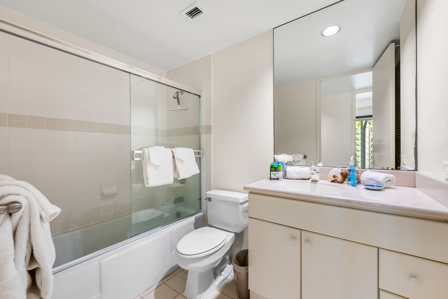 The shared bathroom has a shower/tub combo and a single vanity area.