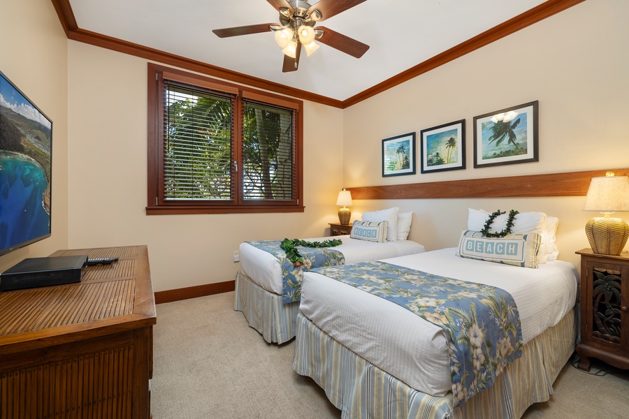Cozy third guest bedroom with twin beds, tropical accents and natural light.