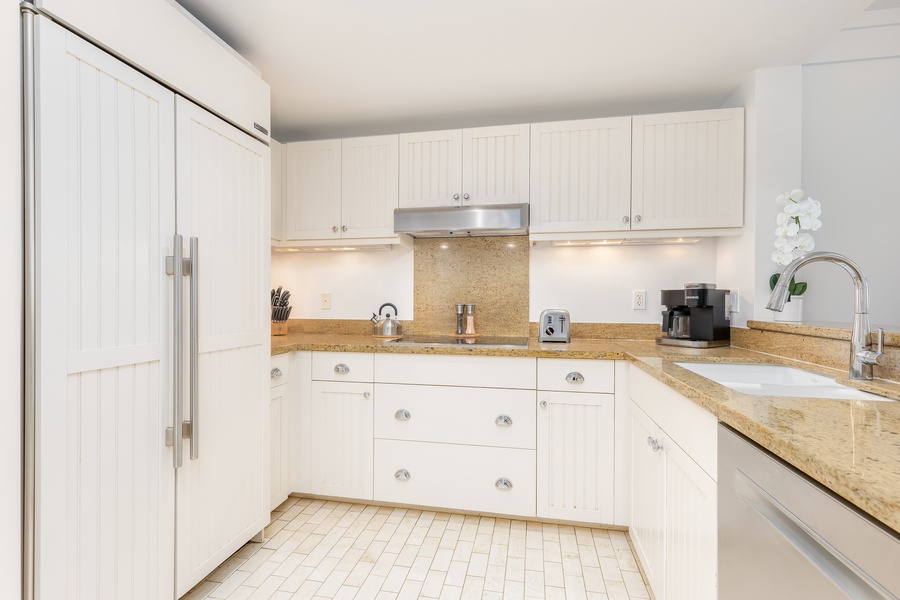 Kitchen invites culinary adventures with granite countertops, white cabinetry, and modern appliances ready for home-cooked meals.