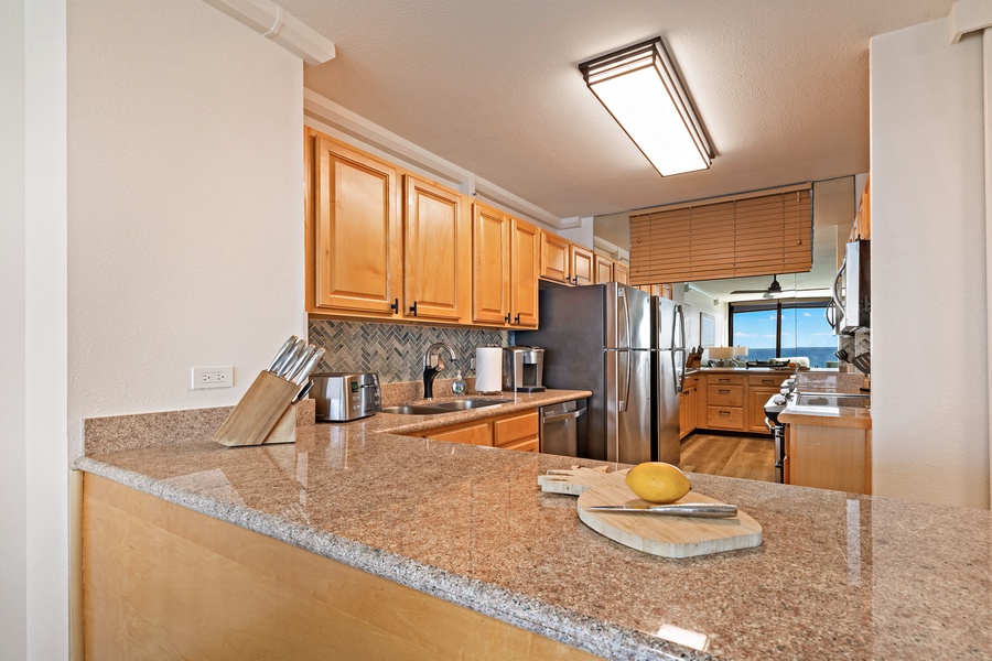 This fully equipped kitchen offers granite countertops, modern appliances, and a spacious layout, perfect for preparing meals with a view.