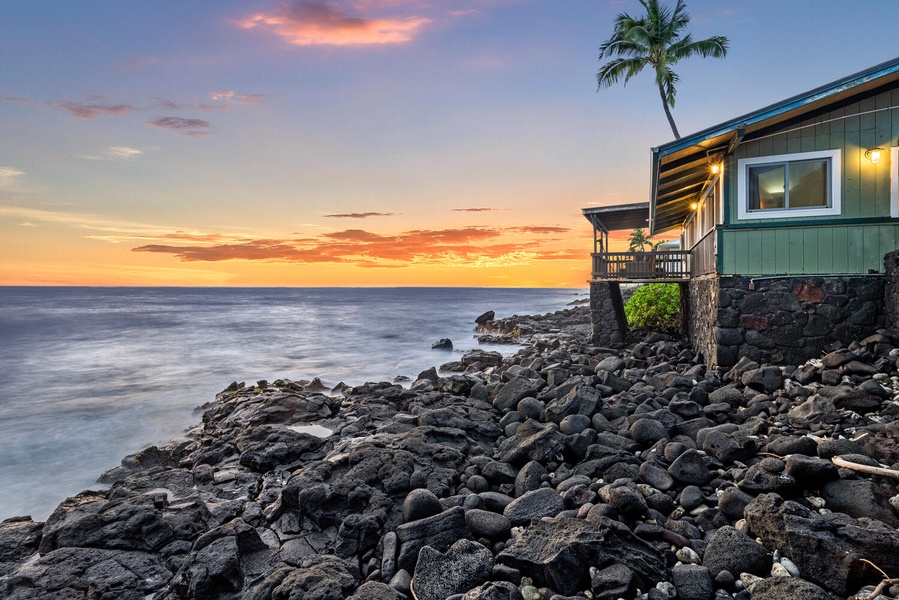 Dramatic oceanfront views with waves meeting the rugged lava rock at golden hour.