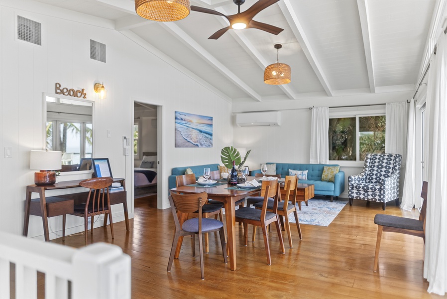 Dining and living flow captured from a second angle, highlighting the home’s spacious layout and warm island-inspired decor.