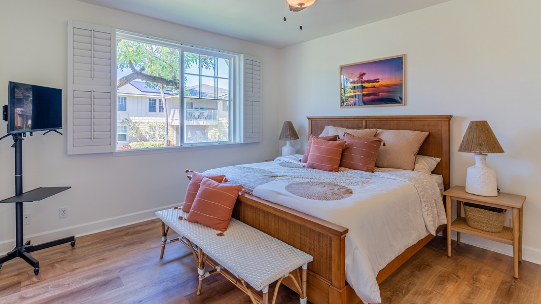 The primary guest bedroom features a king bed, TV, bench seating and scenery.