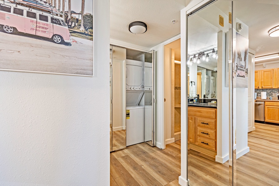 This hallway features mirrored closet doors that conceal a convenient in-unit washer and dryer, making laundry a breeze.