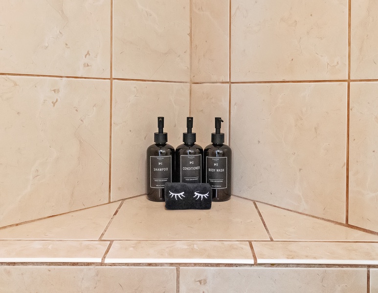 This tile shower is thoughtfully equipped with complimentary luxury bath products, ensuring a spa-like experience for guests