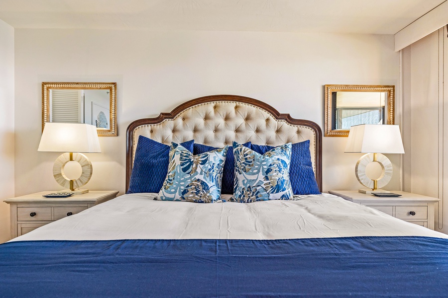 The plush king bed in the primary bedroom invites restful nights with its stylish tufted headboard and soothing blue accents