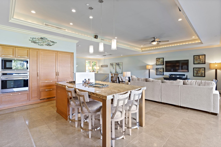 At Wailea Hoolei 93-3, the open kitchen with granite island and bar seating flows into a stylish living area.