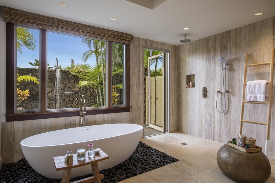 Primary bathroom with soaking tub floating on a bed of river rocks & rainfall walk-in shower