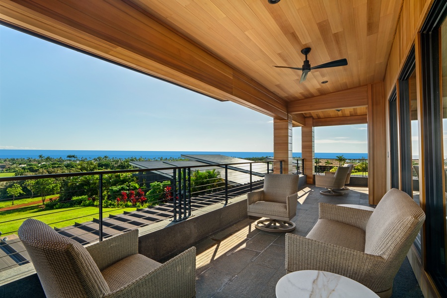 Relax on your private terrace with stunning ocean and golf course views, complete with comfortable seating and cooling ceiling fan overhead.