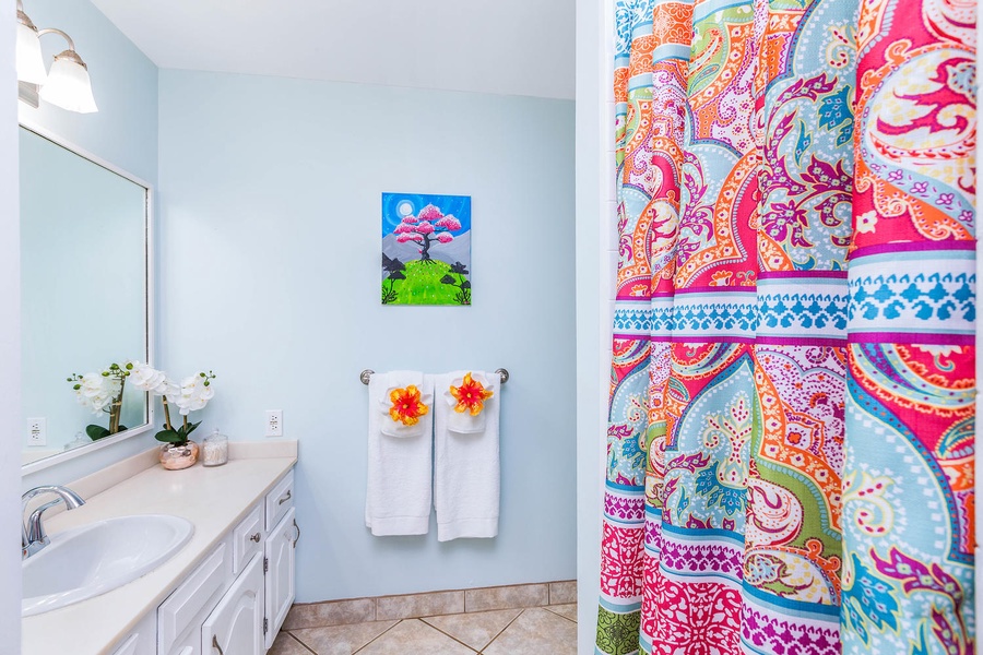 Vibrant bathroom art and soft pastel walls create a playful yet relaxing vibe.