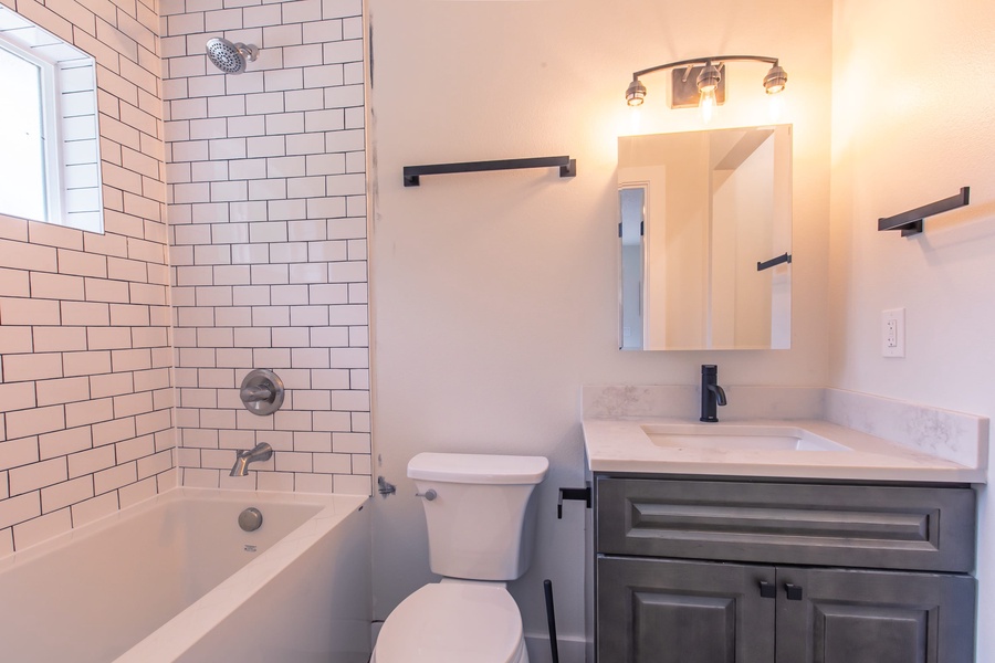 Guest bathroom with a shower/tub combo comes fully stocked with towels, shampoo, conditioner, and body wash