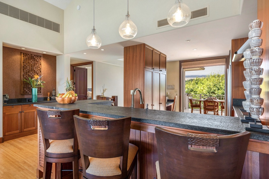 View from bar seating into the modern gourmet kitchen and breakfast table on deck beyond.